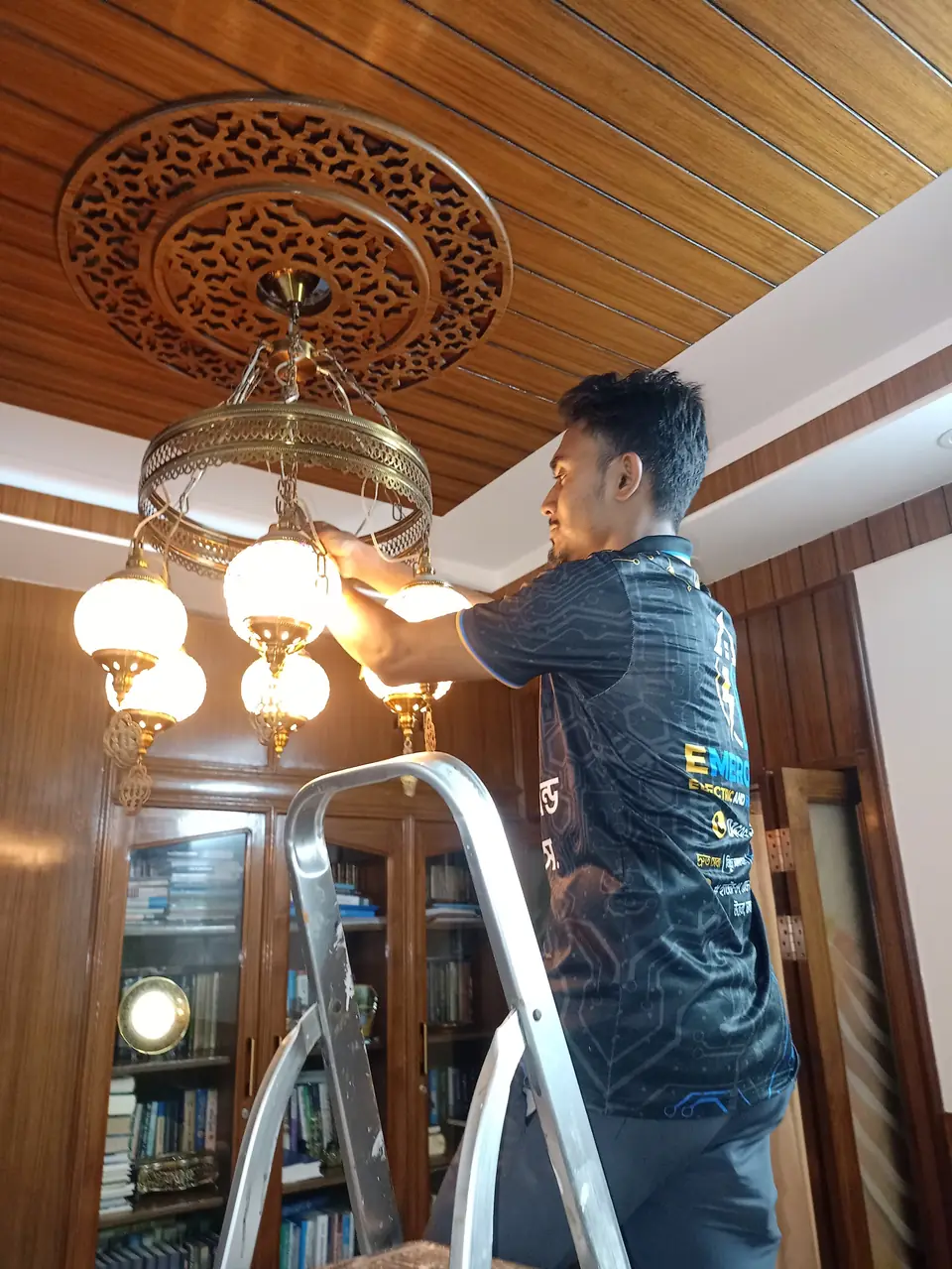 Chandelier installation on a ladder