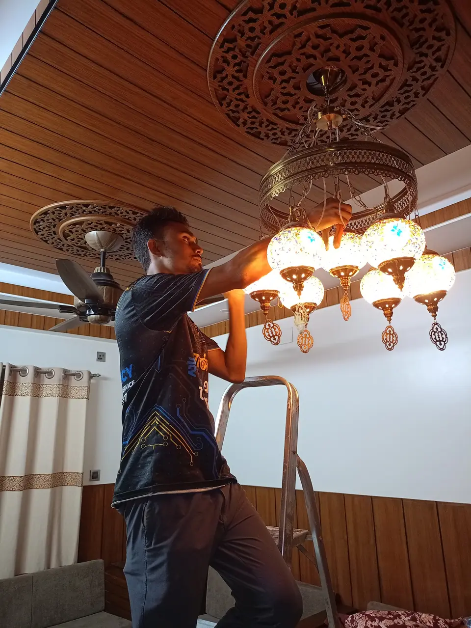 Technician connecting a decorative ceiling light