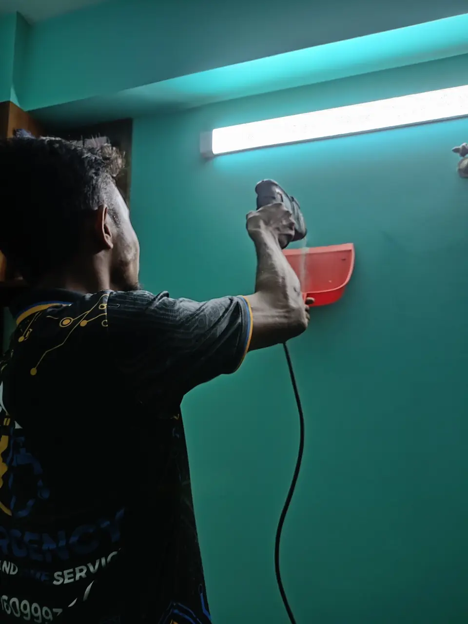 Technician drilling for a wall mount